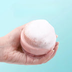 Pink silicone shampoo dispensing bath brush covered with rich foam.