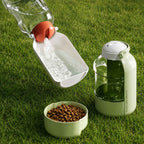 Portable dog and cat water and food bottle on grass for outdoor travel and walking.